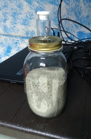Due barattoli di sabbia, unoi contenente circa 1kg di materiale e l'altro pochi grammi
